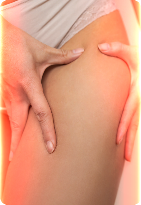 Close-up of a person’s thigh with a warm red light glow, illustrating the Energy Lounger anti-aging therapy effect.
