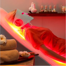 EnergyLounger red light therapy spa session with a person using an LED facial mask.