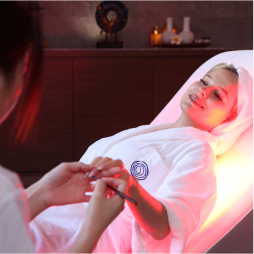 Close-up of a woman in a white robe receiving a relaxing hand and arm treatment during a spa session.